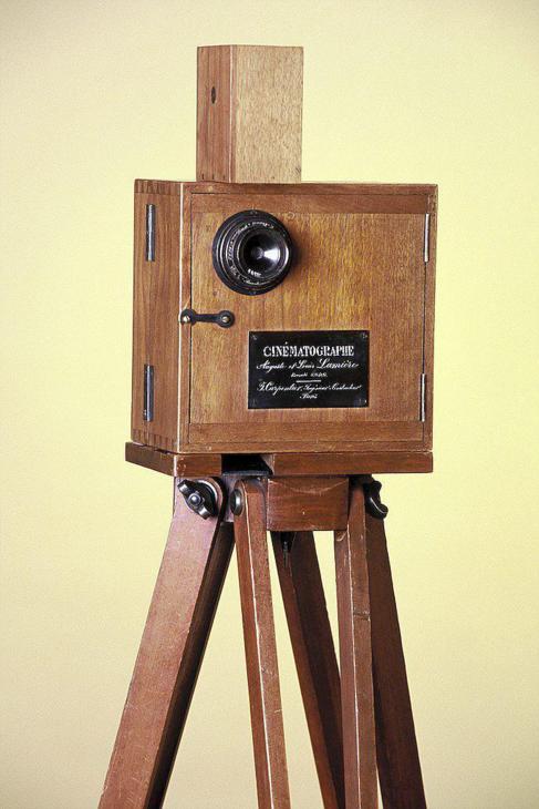 Cinematógrafo inventado por los hermanos Lumière, 1895. El aparato consistía en una caja de madera con un objetivo y una película perforada de 35 milímetros. Ésta se hacía rodar mediante una manivela para tomar las fotografías instantáneas que componían la secuencia (que no duraba más de un minuto) y proyectar luego la filmación sobre una pantalla.